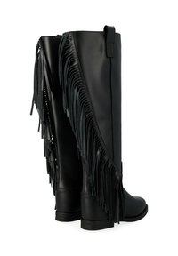 Bottes hautes en cuir noir avec des franges verticales sur le côté extérieur, semelle plate et un talon. Le design présente une silhouette épurée.
