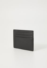 Svart skinnkortholder med et stilrent design, som har flere kortlommer og en jevn tekstur. Stikksydde kanter og minimalistisk profil.
