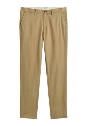 Pantalon chino beige à jambes droites avec passants de ceinture, poches latérales, fermeture avant par bouton et étiquette GANT à l'intérieur de la ceinture.
