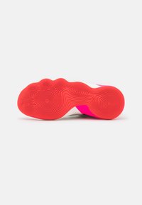 Suela de zapato con un diseño ondulado, predominantemente en rosa y blanco. La suela roja texturizada presenta patrones circulares para el agarre y la tracción.