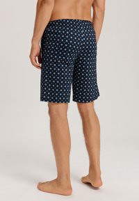 Navyblå mönstrade badshorts med en avslappnad passform, med en stretchmidja och ett blommigt mönster i ljusblått och vitt.
