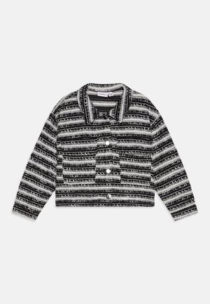 Chaqueta recortada de rayas blancas y negras, con mangas largas, botones delanteros, cuello y un único bolsillo en el pecho con solapa y botón.