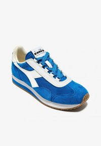 Sneaker blu in suede con sovrapposizione in pelle bianca, lacci blu e suola in gomma con grip texturizzato. Branding sulla linguetta.