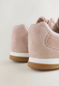Baskets en suède rose avec une finition texturée, dotées d'un intermédiaire blanc et d'une semelle extérieure en caoutchouc couleur gomme. Design arrondi avec des détails de couture subtils.