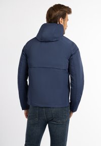 Marineblå, isoleret jakke med høj krave og hætte. Har en glat tekstur og et kompakt design. Bagview viser sideløsninger.