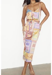 Bunt gemustertes Midi-Kleid mit Spaghettiträgern, tailliertem Bund und einer Mischung aus geometrischen und floralen Designs in Pastellfarben.