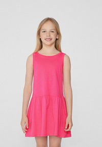 Robe en coton sans manches rose avec un col rond, une jupe évasée et une taille froncée. Texture lisse et lignes simples et épurées.