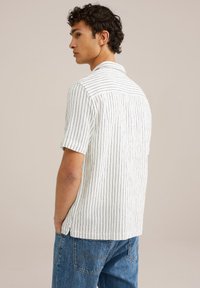 Short-sleeve shirt in white fabric with narrow vertical stripes in dark color. Features a collar and a straight back hem design.