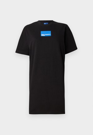 Fekete pamut póló, laza szabással, rövid ujjakkal, elöl kék téglalap alakú logóval. Egyszerű dizájn, minta vagy díszítés nélkül.