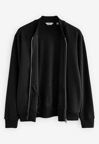 Veste noire zippée avec une texture lisse, col et poignets côtelés. Dotée de deux poches avant et d'une fermeture éclair sur toute la longueur devant.