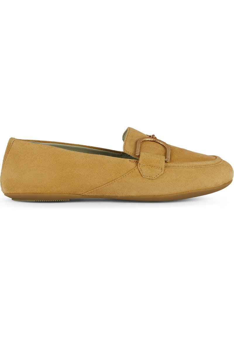 Mocassini in suede color crema con suola piatta, dotati di un dettaglio decorativo a forma di fibbia sulla parte superiore. Texture liscia e design semplice.