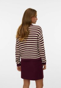 Maglione a righe in crema e bordeaux con polsini e orlo a coste, abbinato a una gonna bordeaux uniforme. Morbido tessuto a maglia, vestibilità comoda.