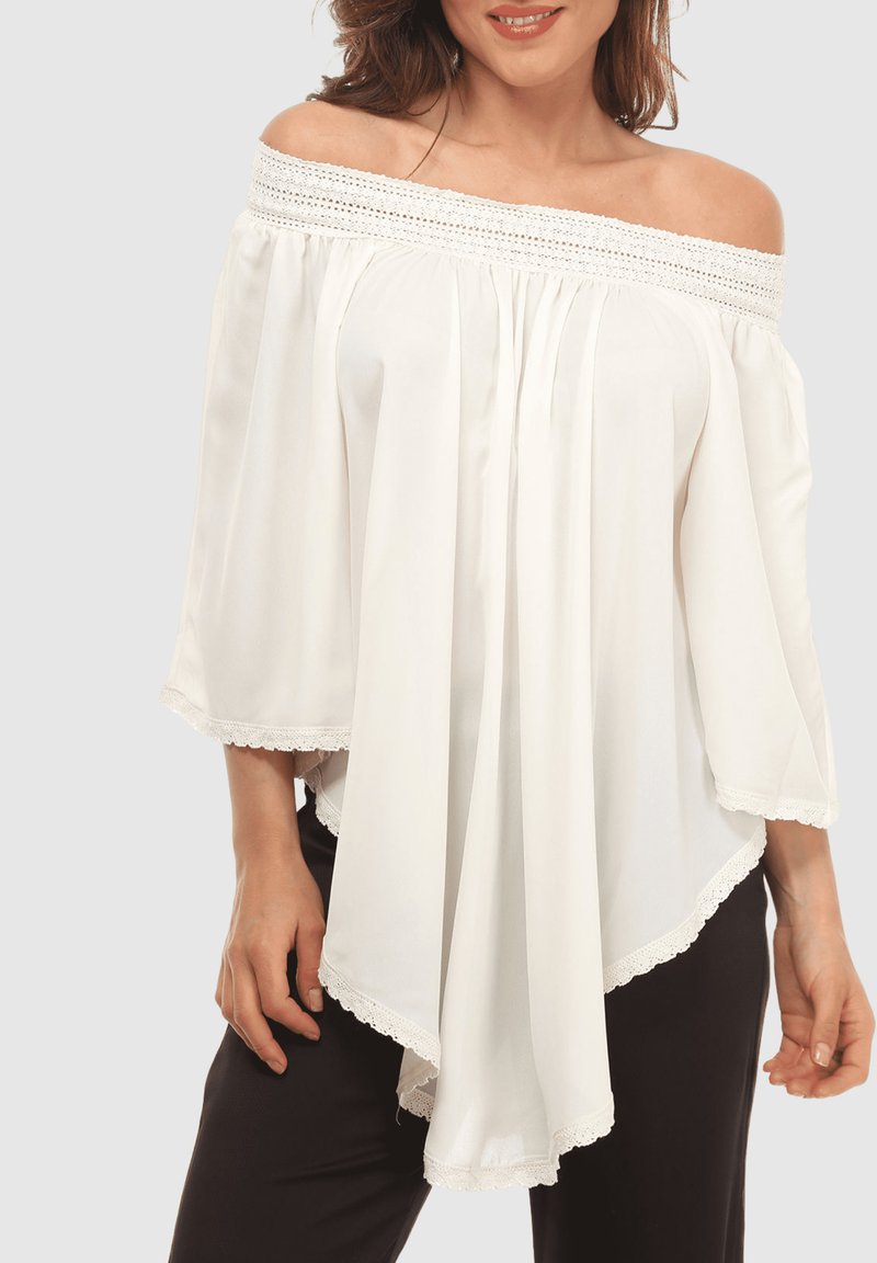 Blusa blanca sin hombros hecha de tela ligera, con un borde de encaje texturizado a lo largo del escote y el dobladillo, y mangas fluidas.