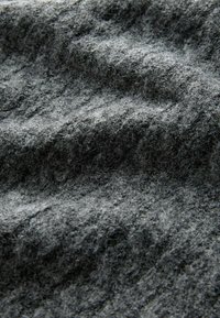 Pilkas tekstūruotas audinys su minkštu, pūkuotu išvaizda, turintis šviesių ir tamsių gijų, rodančių bangas ir raukšles visame paviršiuje.