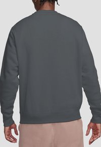 Gray sweatshirt made of soft fabric, featuring a crew neck, long sleeves, and a smooth texture, with ribbed cuffs and hem.