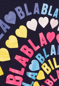 Tessuto blu con disposizione circolare di lettere colorate e cuori. Il testo include "BLA" in finiture rosa, giallo, blu e metalliche.