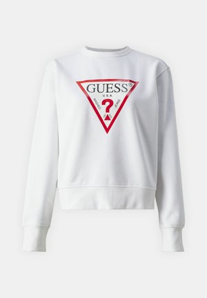 Sweatshirt blanc avec un design court, arborant un audacieux logo triangulaire rouge avec le texte "GUESS U.S.A." et un point d'interrogation au centre.