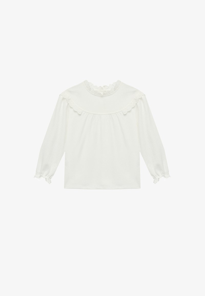 Blusa blanca de manga larga con cuello y puños de encaje con borde festoneado, detalle fruncido en la pechera y corte suelto.