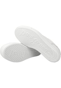Zapatillas de goma blancas con una suela texturizada que presenta agarres circulares y detalles de logotipo en relieve. Punta redondeada y diseño minimalista.
