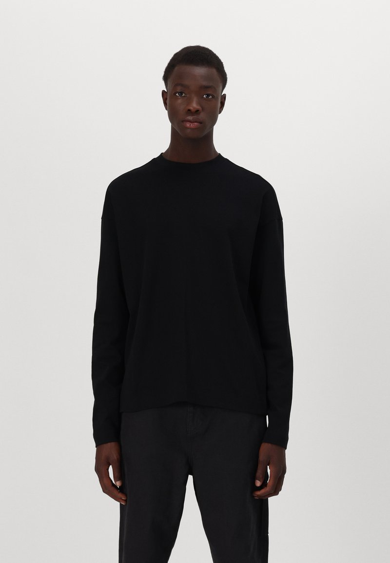 Schwarzes langärmliges T-Shirt aus Baumwolle mit Rundhalsausschnitt und relaxter Passform. Minimalistisches Design, keine sichtbaren Logos oder Muster.