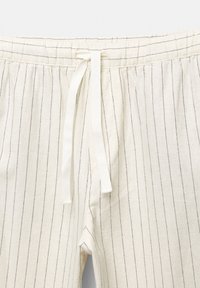 Pantalones de mezcla de lino de color claro con rayas verticales en azul marino y una cinturilla elástica. Cuenta con un cordón en la cintura para ajuste.