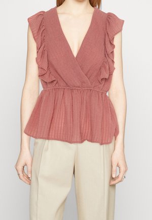 Gerafftes, V-Ausschnitt, staubrosa Oberteil aus leichtem, strukturiertem Stoff; elastischer Bund, der eine Peplum-Form schafft, kombiniert mit beigen Hosen.