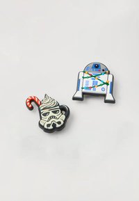 Due due spille smaltate: una tazza di stormtrooper con panna e un bastoncino di zucchero, e R2-D2 con luci di Natale. Entrambi sono colorati con design dettagliati.