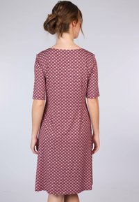 Kurzarmkleid mit einem geometrischen Muster in Burgunderrot und Creme, ausgestattet mit einem Rundhalsausschnitt und einem knielangen Saum. Weicher, glatter Stoff.