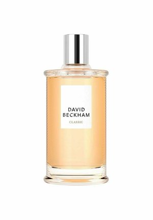 Klart glas parfume flaske med ribbet tekstur, sølvlåg og en hvid etiket, der viser "DAVID BECKHAM CLASSIC." Lys amberfarvet væske indeni.