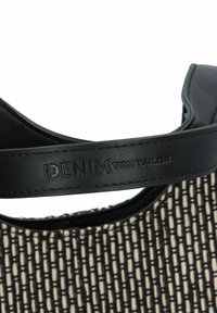 Bracelet en cuir noir avec logo "DENIM TOM TAILOR" en relief, tissu tissé texturé en crème avec un motif à carreaux noirs.