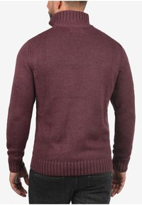 Dunkelweinroter Strickpullover mit hohem Kragen, gerippten Bündchen und Saum. Mitteldicke mit strukturierter Oberfläche, von hinten gezeigt.