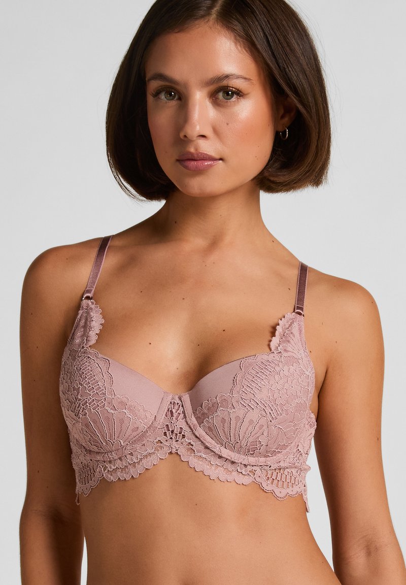 Pink lace bra featuring a scalloped edge, underwired cups, and adjustable satin straps. Delicate floral patterns enhance the design.