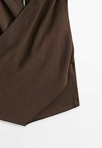 Enveloppe en tissu marron avec une texture lisse, présentant un design drapé et des bords angulés, créant une forme asymétrique.