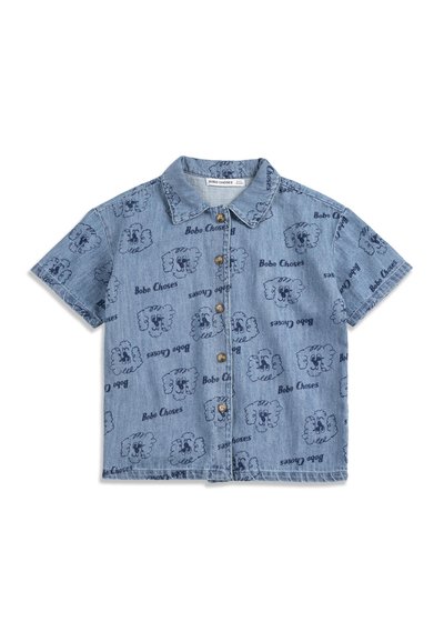 Chemise en jean bleu à manches courtes avec col, ornée de motifs répétitifs de visages d'animaux en dessin animé bleu foncé et de texte "Bobo Choses".