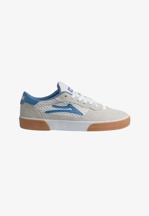 Low-top sneaker with white mesh and beige suede upper, blue logo and heel detail, white laces, and gum rubber sole.
