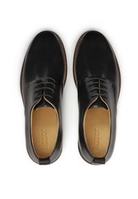 Črne usnjene oblečne čevlje z gladko teksturo, zaobljenim prstom in šestimi luknjicami za vezalke. Tan vložki in kontrastni rjavi šivi na podplatu.