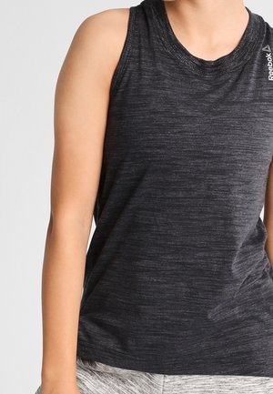 Bezrekawnik sportowy w ciemnoszarym kolorze z subtelnym wzorem melanżowym, noszony przez osobę, w połączeniu z jasnoszarymi szortami.