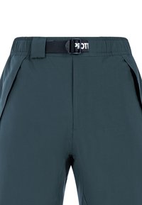 Donker teal broek met een vlakke voorkant, een zwarte tailleband, een verstelbare riem en subtiele zijplooien voor meer bewegingsvrijheid.