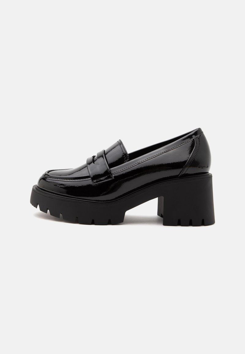Mocassin à talon épais en cuir verni noir avec semelle à crampons et détail de sangle sur le dessus, vu de profil sur fond blanc.