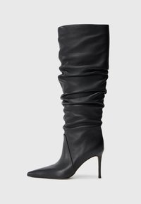 Schwarze, lässige knielange Lederstiefel mit spitzem Schuh und dünnem hohen Absatz auf einem schlichten hellen Hintergrund.