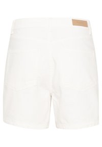 Short en denim blanc avec poches arrière et écusson en cuir marron clair sur la ceinture.