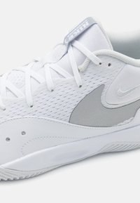 Hvide sportsko lavet af net og læder, med en sølvfarvet Nike Swoosh, hvide snørebånd og et struktureret mellemsål design.
