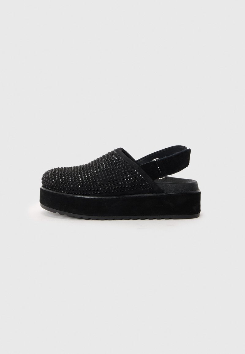 Schwarze Plateausandalen mit einem strukturierten, genoppten Obermaterial und einer Wildlederoberfläche. Verstellbarer Riemen an der Rückseite für einen sicheren Sitz.