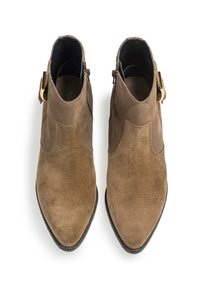 Botines de ante marrón hasta el tobillo con puntera afilada, que presentan un superior texturizado, detalle de hebilla lateral y forro interior negro.
