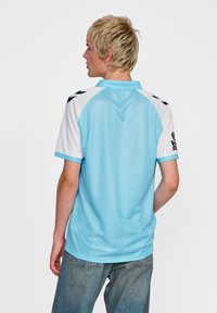 Ljusblå sportpolo med vit krage och ärmar, med svarta detaljer på axlarna. Polyester tyg med vertikala ränder.