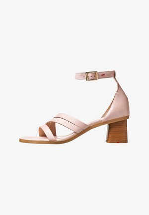 Różowe skórzane sandały z zamkniętym tyłem, otwartym noskiem i dwoma krzyżującymi się paskami. Posiadają zapięcie na nadgarstku z klamrą oraz średni drewniany blokowy obcas.