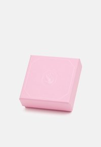 Cadeau en boîte rose fabriqué à partir d'un matériau texturé, avec un design octagonal en relief et un logo central. Compacte et de forme carrée.