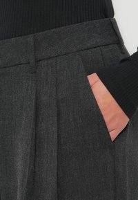 Grijze wolmixbroek met plooien en zijzakken, met een gladde textuur en een getailleerde pasvorm. Ontworpen met een platte tailleband.