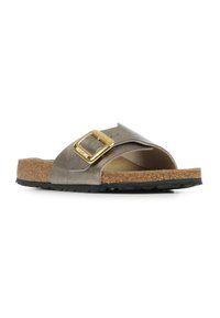 Sandal s plochou podešví, kovově šedým syntetickým svrškem, zlatou sponou, korkovou stélkou a texturovanou černou gumovou podrážkou.
