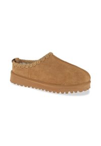 Zapato marrón de ante tipo slip-on con un collar texturizado y una suela gruesa de goma con un patrón estriado para mayor tracción.